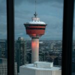 A beautiful view of the Calgary Tower seen through a restaurant window during dusk.